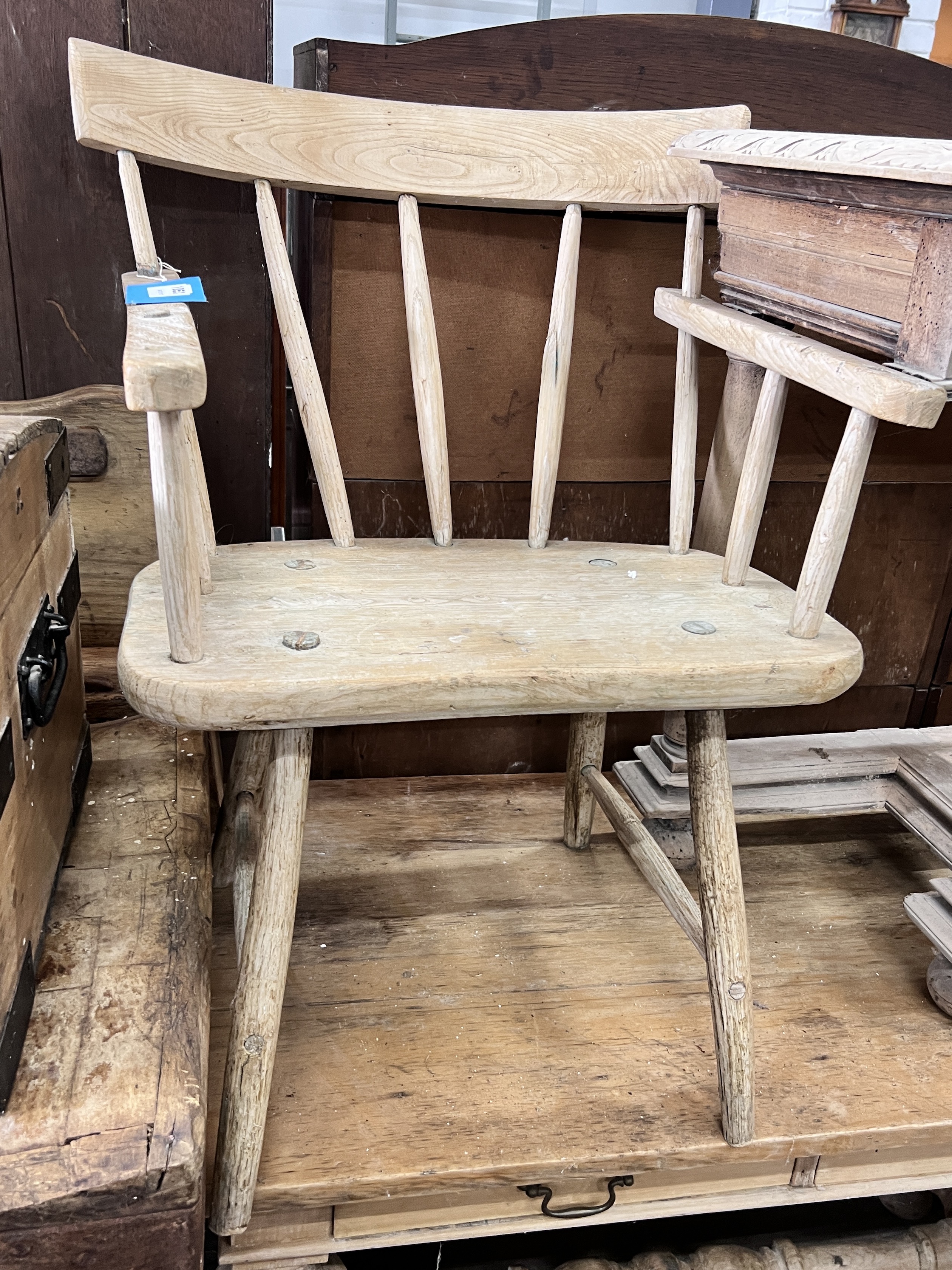 An early 19th century primitive pine comb back elbow chair, width 64cm, depth 57cm, height 81cm